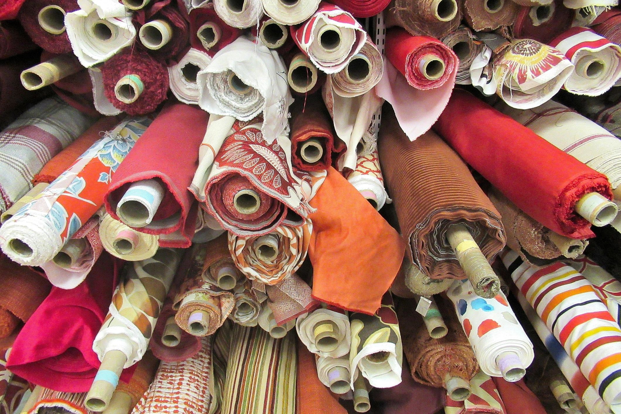 Bolts of fabric in a textile warehouse representing material sourcing and selection